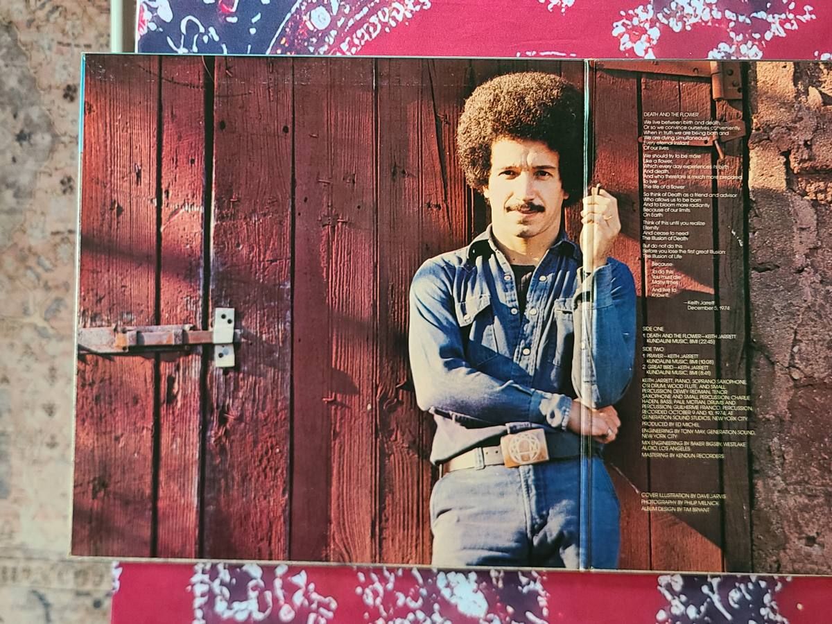 게이트폴드를 펼친 모습. 붉은 나무 문 앞에 청바지 차림으로 앉아 있는 Keith Jarrett과 오른쪽의 시, 크레딧.